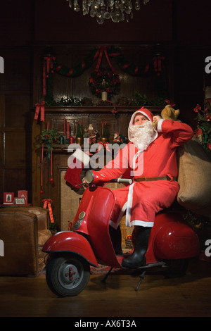 Santa Claus équitation un cyclomoteur Banque D'Images