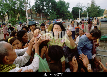 Une femme donne l'aumône aux pauvres à l'extérieur d'un temple à Phnom Penh la capitale du Cambodge Banque D'Images