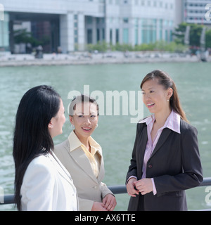 High angle view of three businesswomen smiling at each other Banque D'Images