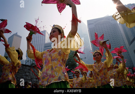 Les filles de la danse dans un défilé du Nouvel An chinois dans le centre de Hong Kong forme tissu et fleurs en plastique et porter des costumes ethniques Banque D'Images