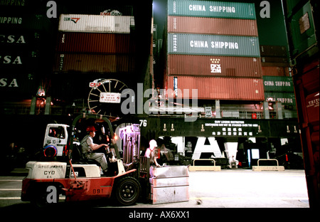 Les conteneurs ont soulevé d'un navire et sur des camions pour le transport au terminal à conteneurs d'Hutchinson, Hong Kong. Banque D'Images