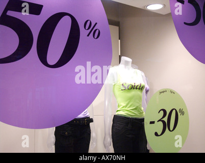 Affichage de promotions de vente dans un magasin de vente au détail comportant des panneaux vibrants indiquant des pourcentages de rabais sur des articles vestimentaires Banque D'Images