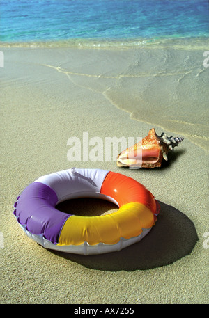 Piscine gonflable anneau et sea shell sur sable avec arrière-plan de la mer bleue Banque D'Images