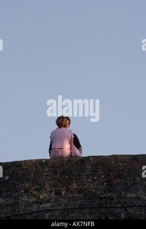 Jeune couple partager un baiser sur les murs de la vieille ville que le soleil commence à définir Saint Valery sur Somme Banque D'Images