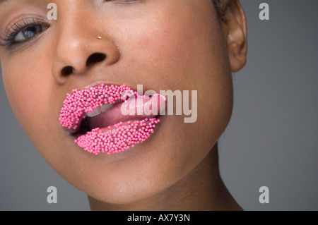 Femme africaine de lécher les lèvres de sprinkles Banque D'Images