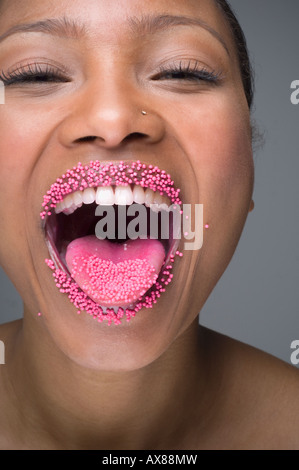 African woman laughing with Sprinkles sur des lèvres Banque D'Images
