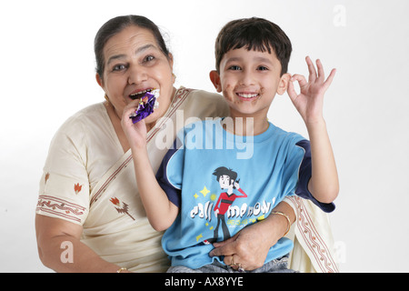 Portrait of a senior woman et son petit-fils de manger du chocolat et souriant Banque D'Images