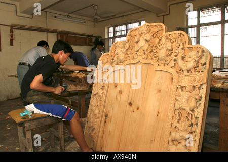 L'Himachal Pradesh Inde Institut Norbulingka sculpture tibétaine et la menuiserie school student working on dos sculptés de Lamas trône Banque D'Images