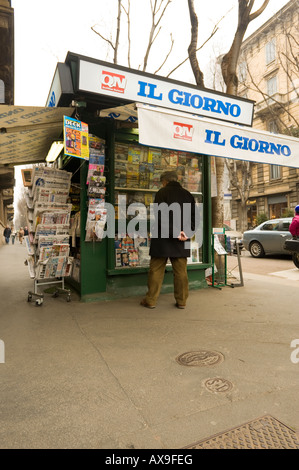 Un ITALIEN PARCOURT LES MAGAZINES À UN TROTTOIR LE LONG DE LA BORNE de Corso Magenta Milan Italie Banque D'Images