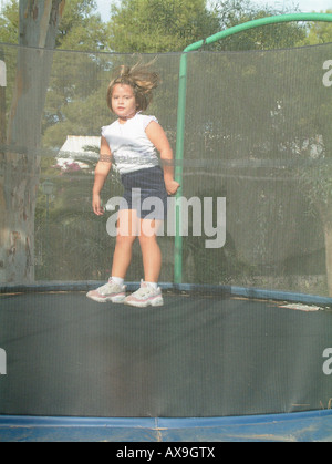 Fille (5 ans) de sauter sur un trampoline Banque D'Images