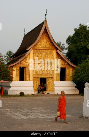 Novice bouddhiste marche à travers Wat Xiang Thong Luang Phabang Banque D'Images