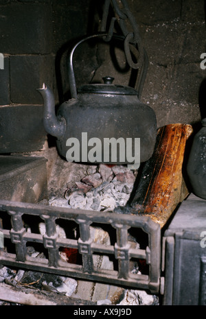 Électrique noirci qui pèsent sur la braise dans un feu ouvert dans un pays de Galles UK Banque D'Images