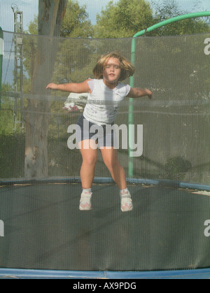 Fille (5 ans) de sauter sur un trampoline Banque D'Images