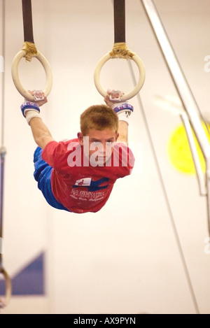 Garçon effectue sur les anneaux de gymnastique au cours de la démonstration de répondre à U S Centre de gymnastique en Californie USA Banque D'Images