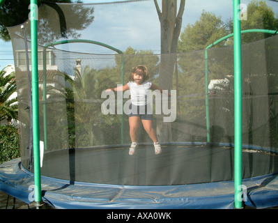 Fille (5 ans) de sauter sur un trampoline Banque D'Images