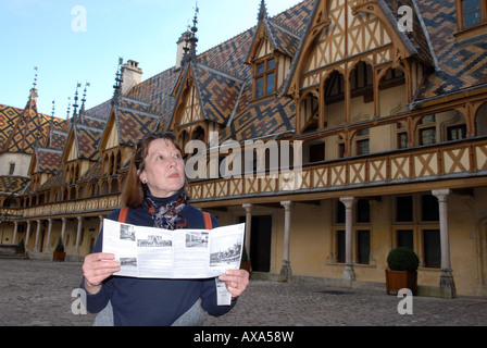 Une femme de lire le guide de tourisme à Hospices de Beaune, l'Hôtel-Dieu de Beaune, bourgogne, france Banque D'Images