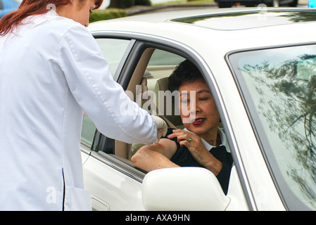 Femme Asiatique se fait vacciner à conduire dans une clinique. Banque D'Images