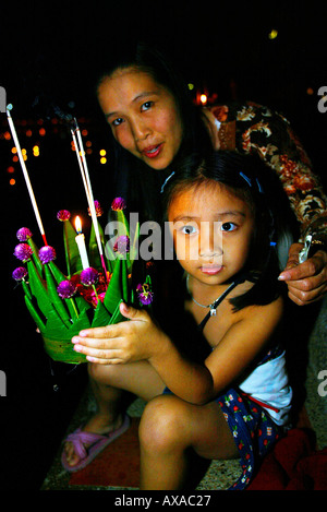 Femme et enfant avec courts de flotteur en Jong Khum Lake, lors de Loy Krathong festival à Mae Hong Son, Thaïlande du nord Banque D'Images