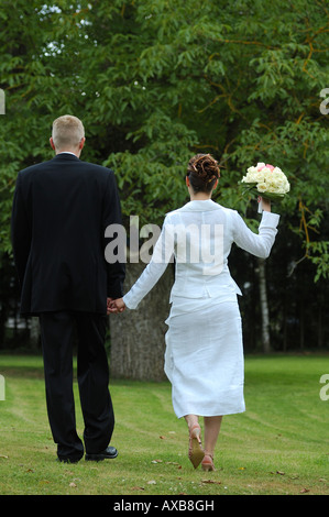 Époux et walking in park with bouquet, France Banque D'Images