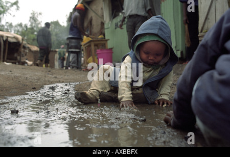 Les enfants de Kibera, le plus grand en Afrique jouent dans la boue. Nairobi, Kenya Banque D'Images