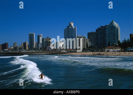 Surfer dans la montée en face de la skyline de Durban, Golden Mile, Durban, Afrique du Sud, l'Afrique Banque D'Images