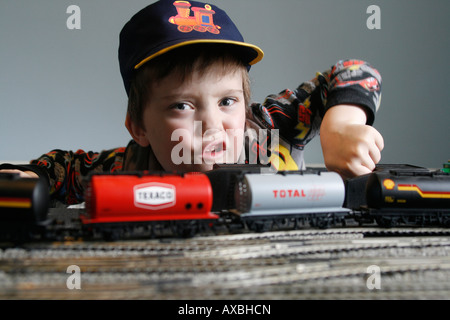 Lewis âgé de 6 et son train électrique Hornby. 00 H0 voie matériel roulant, modèle de la rame avec piste, hat et font partie du jeu. Banque D'Images