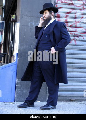 L'homme juif en vêtements traditionnels avec un téléphone mobile, États-Unis d'Amérique, Brooklyn, New York Banque D'Images