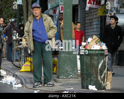 Homme plus âgé à côté d'une poubelle dans une rue sale est à la recherche dans la distance, USA, Brooklyn, New York Banque D'Images