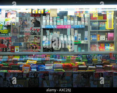 Un homme âgé dans kiosque entouré de produits colorés, USA, Manhattan, New York Banque D'Images