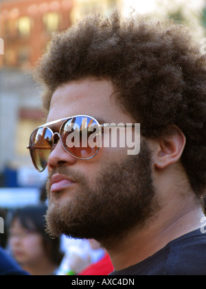 Jeune homme noir avec barbe et de grosses lunettes de soleil dans les parties de l'Union Square sont reflétés, USA, Manhattan, New York Banque D'Images