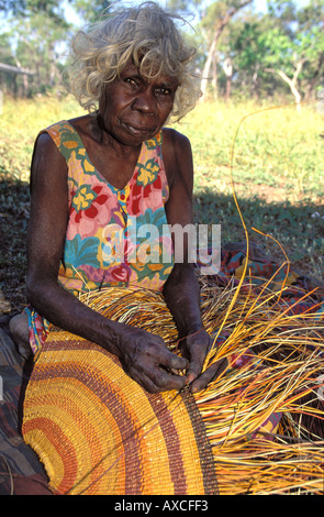 Granny autochtones Rogie Wudam tissant une Yathalamarra pandanus mat Traditionnelle terre d'Arnhem, Australie Banque D'Images