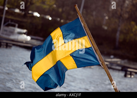 Drapeau suédois sur un bateau avec de l'eau en arrière-plan à Djurgården à Stockholm Banque D'Images