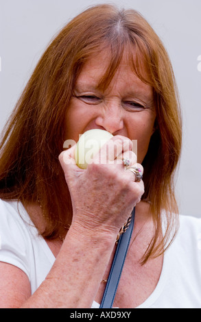 Femme participant à la compétition annuelle au cours de l'alimentation de l'Oignon Oignon Newent Fayre Gloucestershire Newent England UK UE Banque D'Images