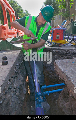 La réhabilitation d'une alimentation en eau de la ville par le remplacement d'un tuyau en victorienne souterrain système avec tube polyéthylène moderne. Banque D'Images