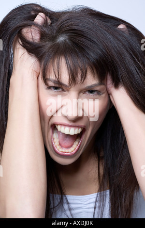 Brunette woman fuming, portrait Banque D'Images