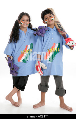 Portrait d'un garçon et une fille portant des uniformes de l'équipe de cricket indienne Banque D'Images