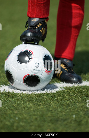 Les pieds d'un joueur de football portant des chaussettes et copie de l'EUROPASS, le matchball officiel du tournoi de football Banque D'Images