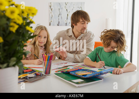 Le père et les enfants à faire leurs devoirs Banque D'Images