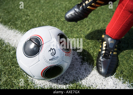 Les pieds d'un joueur de football portant des chaussettes et copie de l'EUROPASS, le matchball officiel du tournoi de football Banque D'Images