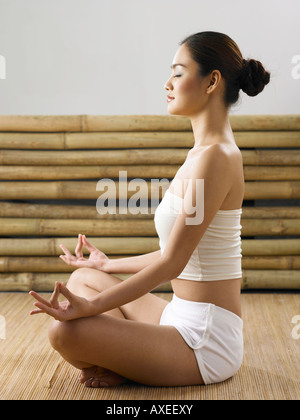 Portrait of a young woman sitting in lotus position Banque D'Images