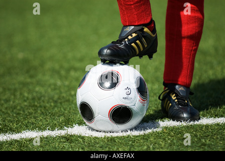 Les pieds d'un joueur de football portant des chaussettes et copie de l'EUROPASS, le matchball officiel du tournoi de football Banque D'Images