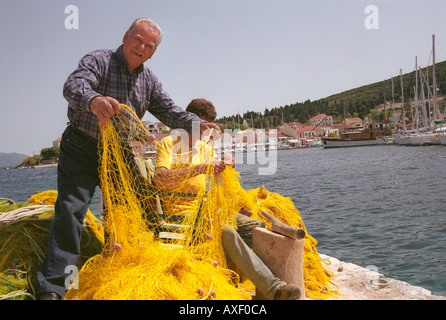 Fixation des filets de pêche pêcheur au village nordique de Fiscardo Kefalonia sur une île Ionienne. Banque D'Images