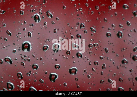 Une photographie de couleur de paysage montrant des gouttelettes de pluie sur la fenêtre de. Une voiture avec l'image d'un panneau stop contenu dans les gouttelettes. Banque D'Images