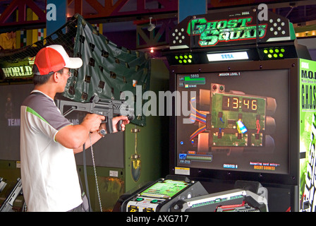 Un jeune homme jouant un jeu d'arcade de tir Banque D'Images