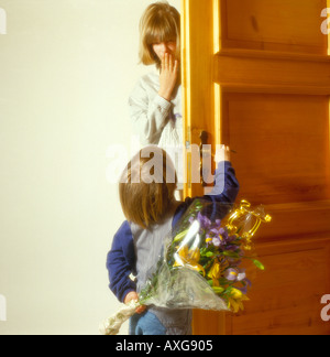 Enfant à la porte est de féliciter avec des fleurs. Photo par Willy Matheisl Banque D'Images