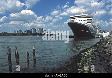 La Cunard paquebot transatlantique Queen Mary 2 à son poste de Brooklyn à New York avec Manhattan derrière Banque D'Images