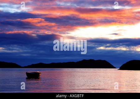 Offshore Sheildaig coucher du soleil sur la côte ouest de l'Ecosse avec un seul bateau amarré dans le calme de l'eau et ciel multicolores Banque D'Images