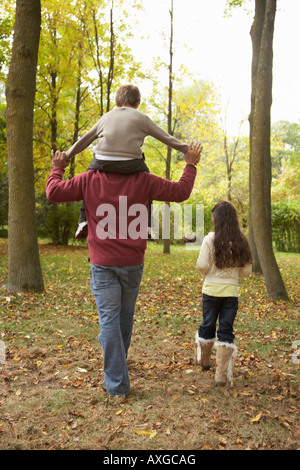 Le père et les enfants à pied à l'automne