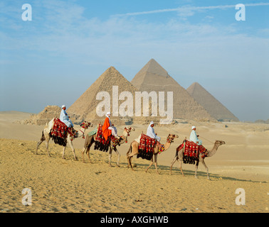 Les chameaux et les cavaliers en face des pyramides, Gizeh, Le Caire, Egypte, Afrique du Nord Banque D'Images