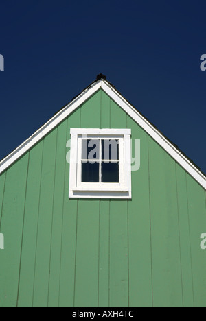 Little green house gable avec un carré quatre volets fenêtre encadrée blanc Banque D'Images